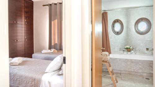 a bedroom with two beds and a tub and a bathroom at Villa Sobre - Spacious And Comfortable in Kounoupidhianá