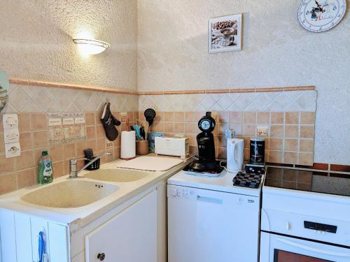 une petite cuisine avec un évier et une cuisinière dans l'établissement Gîte familial avec piscine chauffée, terrain de sport et proximité ZooParc de Beauval et Valençay - FR-1-591-567, à Villentrois