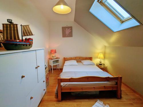 une chambre avec un lit et une lucarne dans l'établissement Gîte familial avec piscine chauffée, terrain de sport et proximité ZooParc de Beauval et Valençay - FR-1-591-567, à Villentrois
