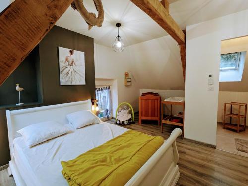 - une chambre avec un grand lit blanc et une couverture jaune dans l'établissement Gîtes de charme avec jacuzzi, piscine chauffée, et activités familiales près du Zoo de Beauval et des Châteaux - FR-1-591-566, à Villentrois