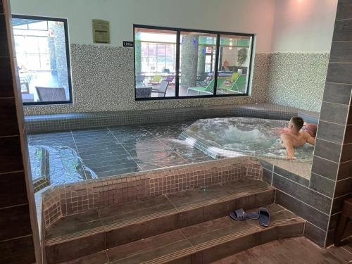 młody chłopiec w jacuzzi w basenie w obiekcie Appartement Lanslebourg-Mont-Cenis, 3 pièces, 6 personnes - FR-1-508-300 w mieście Lanslebourg-Mont-Cenis