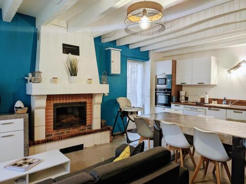 un salon avec une table et une cheminée dans l'établissement Gîte rénové avec piscine chauffée près de Beauval, 10 pers., terrain de sport et nature. - FR-1-591-568, à Villentrois