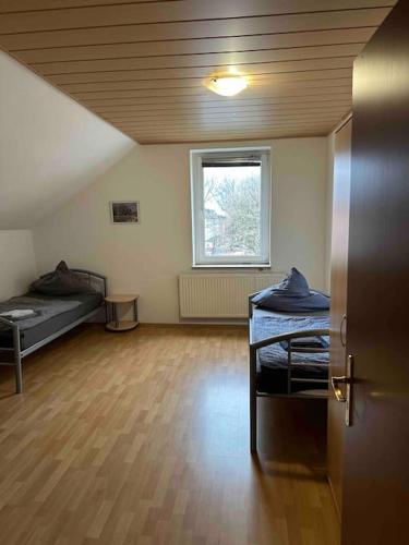 une chambre vide avec 2 lits et une fenêtre dans l'établissement Monteurwohnung für bis zu 8 Personen in Essen, à Essen