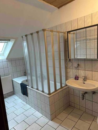 La salle de bains est pourvue d'une douche, d'un lavabo et d'une baignoire. dans l'établissement Monteurwohnung für bis zu 8 Personen in Essen, à Essen