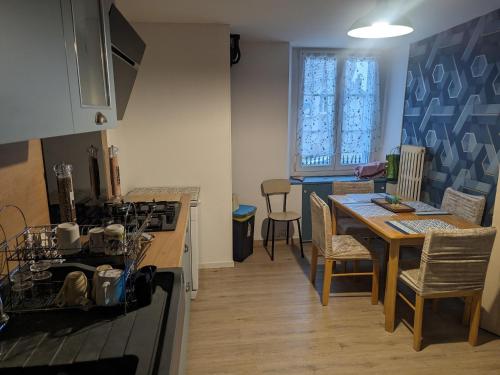 Il comprend une cuisine et un salon avec une table et une cuisinière. dans l'établissement Maison de charme à Bourmont : nature, randonnées et thermes - FR-1-611-96, à Bourmont