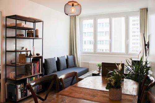 un salon avec une table et un canapé dans l'établissement Bright nest - view on the top of the Eiffel Tower, à Paris