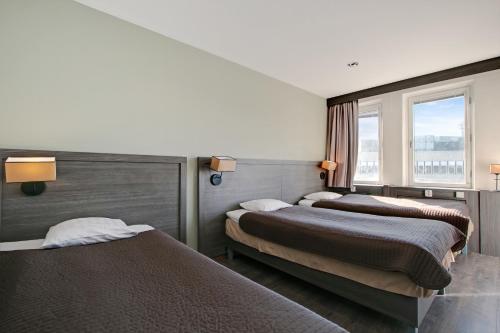Brunnby Hotel في ستوكهولم: غرفة فندقية بسريرين ونافذة