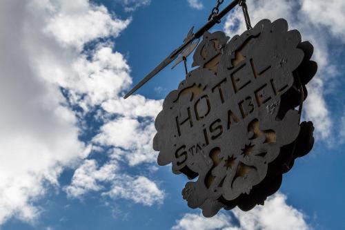 a sign hanging from a pole with the sky in the background at Hotel Santa Isabel in Toledo