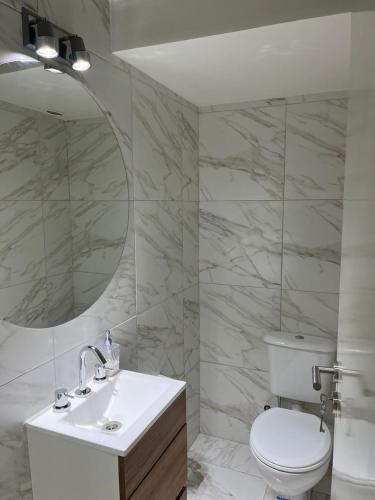 a bathroom with a toilet and a sink and a mirror at Departamento Nº 6 en complejo semiprivado (2 habitaciones) in San Martín