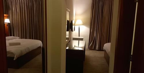 um quarto de hotel com uma cama e um espelho em P.A.S.H.A BOUTIQUE HOTEL em Amã