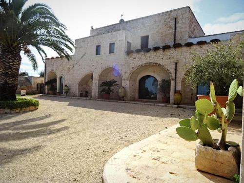 a building with a palm tree in front of it at Masseria Demma in Polignano a Mare