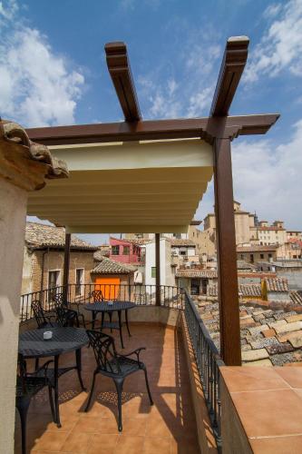 a patio with tables and chairs on a balcony at Hotel Santa Isabel in Toledo