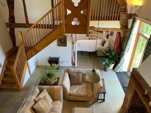 a living room with a couch and a bed at Unique 17c listed Barn in a Shropshire hamlet. in Albrighton