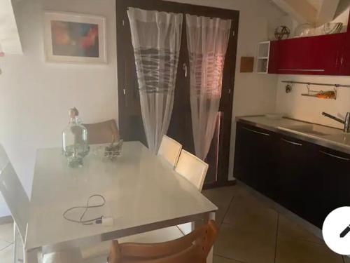 uma cozinha com uma mesa branca e uma bancada em Stupendo appartamento em Mozzo