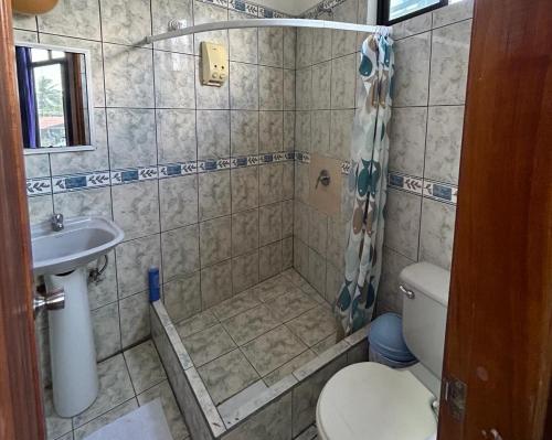 a bathroom with a shower and a toilet and a sink at Hotel Isla del descanso in Puerto Villamil