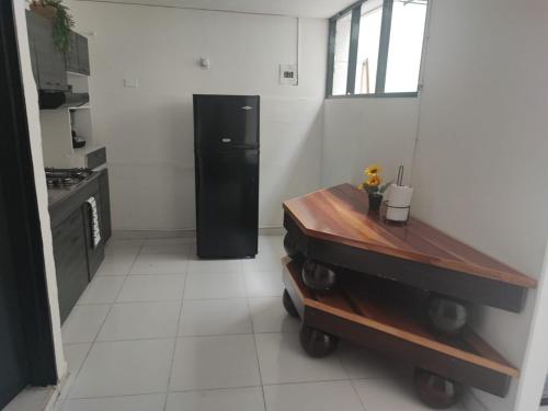 a kitchen with a black refrigerator in a room at Habitación en encantadora casa en Itagui in Itagüí