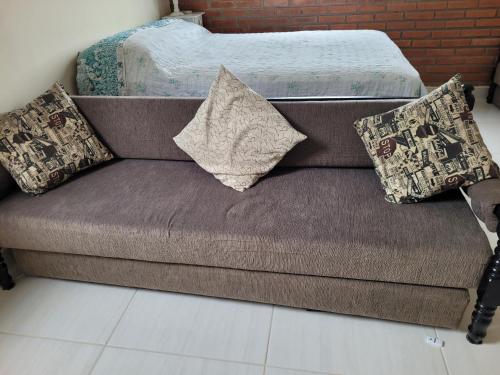 a couch with pillows on it in a room at Apto completo - Solemar/PG in Praia Grande