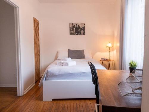 1 dormitorio con cama blanca y mesa en Perfect 4 Groups Big Livingroom Backyard Wifi en Montreal
