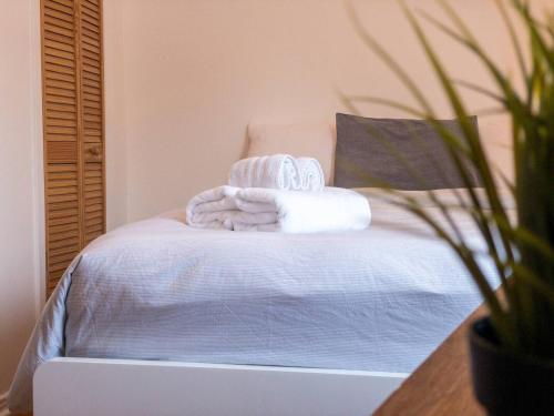 een slaapkamer met een bed met handdoeken en een laptop bij Perfect 4 Groups Big Livingroom Backyard Wifi in Montreal