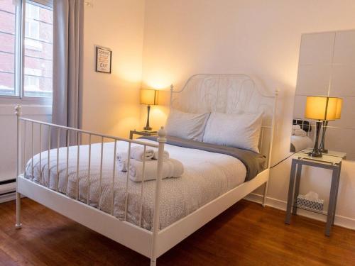 um quarto com uma cama branca e 2 candeeiros em Lemiltonplace Beautifully Renovated 4 Ur Enjoyment em Montreal
