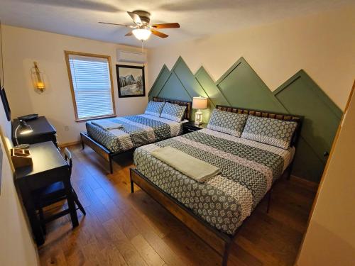 a bedroom with two beds and a table and a piano at Swept Away Chalet - Luxurious NEW 6 BR Home Sleeps 16 Hot Tub Linens and Towels in Albrightsville