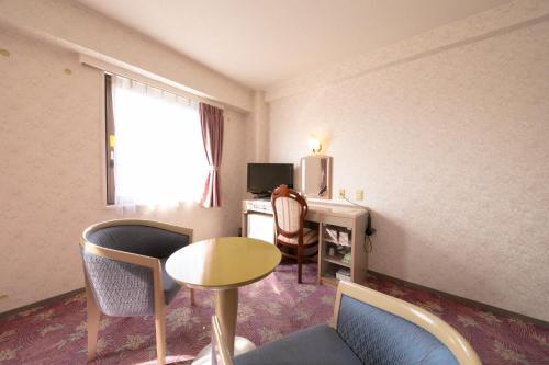 een hotelkamer met een bureau, een computer en stoelen bij Main Hotel - Vacation STAY 85481v in Miyakonojo