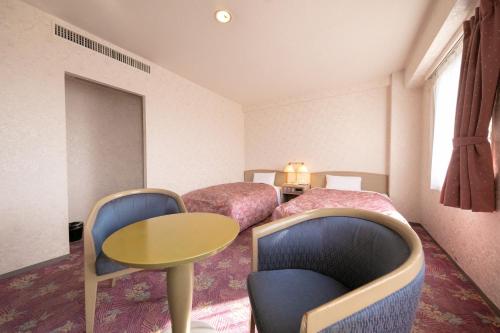 Habitación de hotel con 2 camas, mesa y sillas en Main Hotel - Vacation STAY 85409v, en Miyakonojō