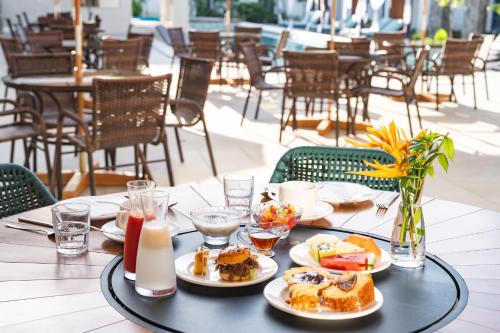 a table with plates of food on a table in a restaurant at Resende Imperial Hotel & Spa in Itacaré