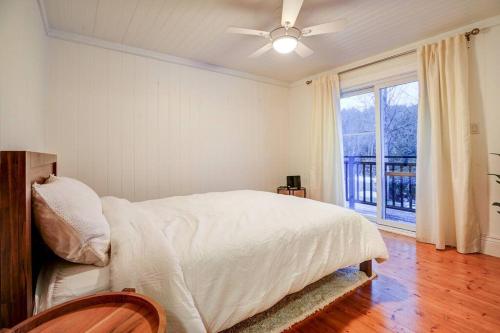 a white bedroom with a bed and a window at Meadowcreek Cottage in Utterson
