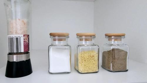 four glass jars filled with different types of spices at Kolo Apartament in Koło