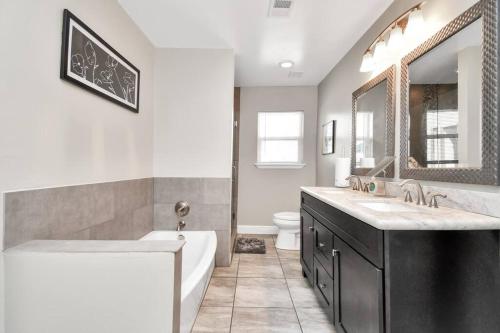 uma casa de banho com uma banheira, um lavatório e um WC. em Family Friendly - Spacious - Near NRG Med Center em Houston