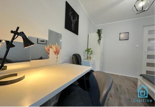 an office with a desk with a lamp and chairs at Jager Room 10 Min to Old Town Gdańsk,PKP & Shopping Mall in Gdańsk