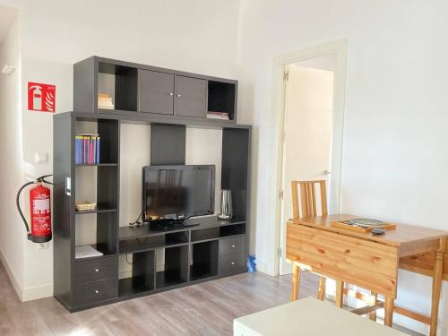 een zwarte boekenplank met een tv en een bureau bij One bedroom appartement with wifi at Madrid in Madrid