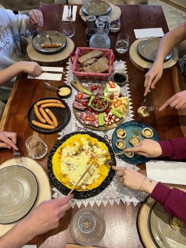 un grupo de personas sentadas alrededor de una mesa con comida en The Barn, en Şirnea