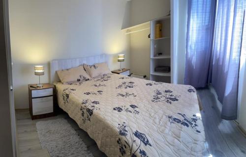 a bedroom with a bed with a blue and white comforter at Apartamento Central Quillota con estacionamiento in Quillota
