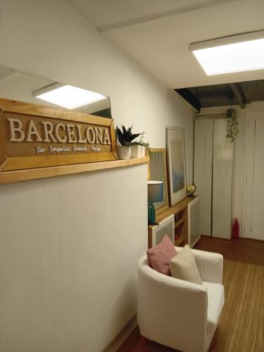 a living room with a white chair and a sign at Bonavista Montgat in Montgat