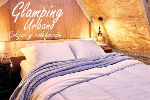 a bedroom with a bed with a sign on the wall at Glamping Urbano Bogota in Bogotá