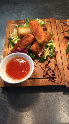 a plate of food with a salad and a bowl of sauce at The Emmbrook Inn Hotel in Wokingham
