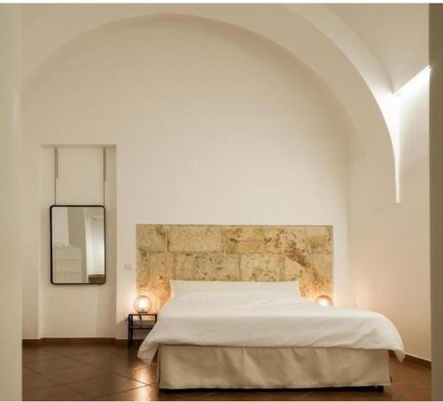 een slaapkamer met een wit bed en een spiegel bij Martinirooms in Altamura