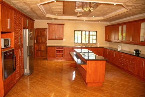 a large kitchen with wooden cabinets and stainless steel appliances at Lizpeter guest house in Elim