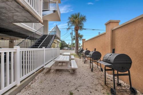 a row of picnic tables in front of a building at Atlantic Ave: 3 Bed 2 Bath Condo Walk to Beach in Tybee Island