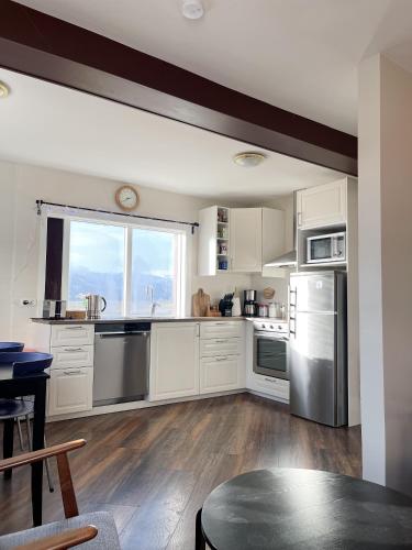 a kitchen with white cabinets and stainless steel appliances at Setberg Guesthouse in Nesjum