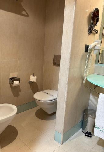 a bathroom with a toilet and a sink at Gran Hotel Liber & Spa Playa Golf in Noja
