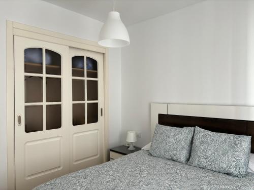 a bedroom with a bed and a white door at Ocón 2 in Lebrija