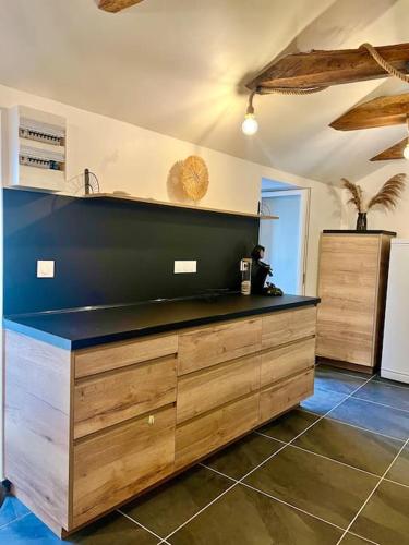 a kitchen with wooden cabinets and a black counter top at Appartement Nicolas in Aujac