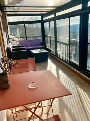 a room with a table and chairs on a balcony at Appartement Nicolas in Aujac