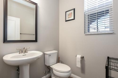 La salle de bains est pourvue d'un lavabo, de toilettes et d'un miroir. dans l'établissement Sunny Vegas Oasis Escape, à Las Vegas