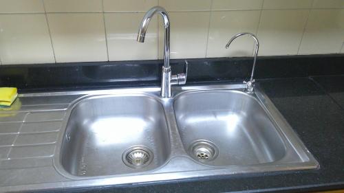 a stainless steel sink with two faucets in a kitchen at Ruby Star Couples Hostel G P 1&2 in Dubai