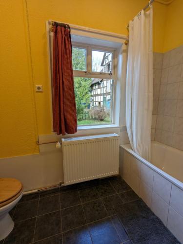 a bathroom with a tub and a toilet and a window at „Altes Forsthaus“ am Schloss in Uelzen