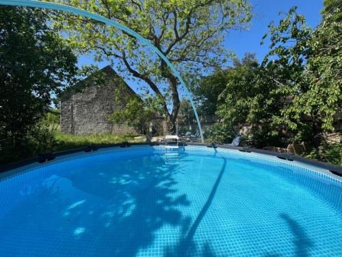 une grande piscine bleue avec une fontaine dans l'établissement Le SAN - Chambre d'hôtes INCLUSIVE & ÉCORESPONSABLE, à Beauchery